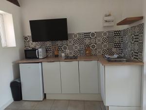 a kitchen with a counter with a tv on the wall at Studio cosy in Sorgues