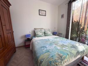 a bedroom with a bed and a large window at T2 dans villa plain-pied avec parking privé in Canet-en-Roussillon