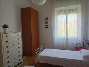 une chambre avec un lit, une commode et une fenêtre dans l'établissement Stella Marina, à Porto San Giorgio
