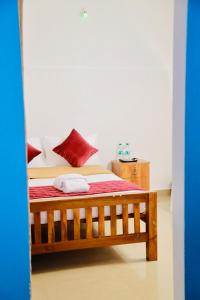 瓦尔卡拉Varkala Escape Resort的一间卧室配有一张带红色枕头的木床。