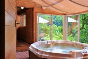 a large tub in a room with a large window at Pension Asuka inn Daisen in Hoki +57 photos