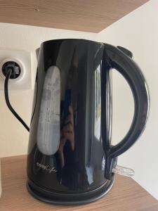 a black coffee pot with a wii controller in it at Le cosy marnais, centre ville, vue cathédrale in Reims