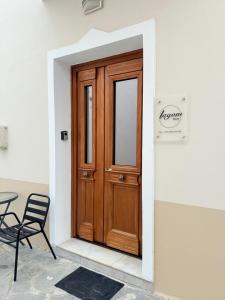 a wooden door in a white wall with a black chair at Lagom House in Panagia +7 photos