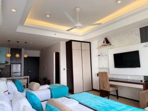 a hotel room with two beds and a flat screen tv at Ocean Breeze Seaview Studio by AquaBlu in Negombo