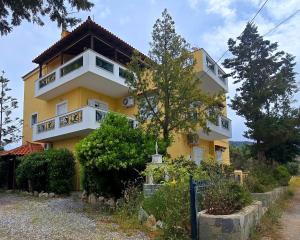 a yellow building with a fence in front of it at Annie's summer house in Plytra