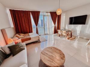 ein Wohnzimmer mit einem Bett und einem Tisch in der Unterkunft Boho Chic Studio, Pool & Gym in Abu Dhabi