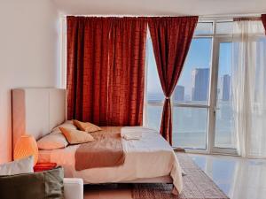ein Schlafzimmer mit einem Bett und einem großen Fenster in der Unterkunft Boho Chic Studio, Pool & Gym in Abu Dhabi + 14 Fotos