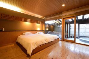 a bedroom with a large bed and a large window at Yatsusankan-Children 6 years and older only in Hida +75 photos