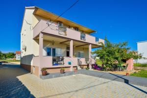 a large pink building on a street at Apartments Duje in Bibinje