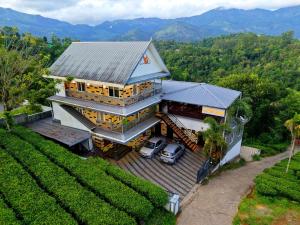 eine Luftansicht eines Hauses mit zwei davor geparkt in der Unterkunft The Svarga Munnar Hill View resort in Munnar