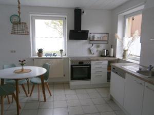una cocina blanca con mesa, mesa, mesa y mesa con mesa y mesa en Ferienwohnung Lina und Hans, 