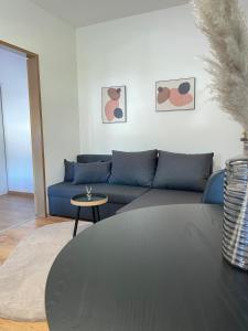 a living room with a blue couch and a table at Zentrale Wohnung mit Georgenblick in Untermicheldorf