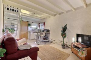 a living room with a red couch and a kitchen at Les petites landes in Pleumeleuc
