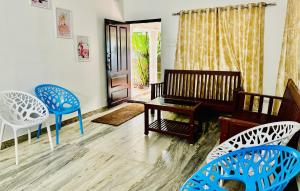 瓦尔卡拉Varkala Escape Resort的客厅里有蓝色的椅子和桌子 更多21张照片