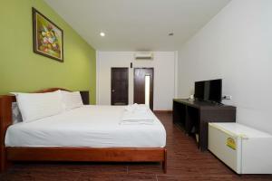 a bedroom with a white bed and a television at Dancenter Khaosan Park Hotel in Bangkok