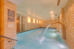 a lap pool with a water fountain in a building at Hotel Diament Arsenal Palace Katowice - Chorzów in Chorzów