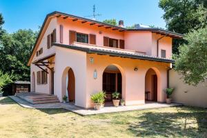 an orange and white house with a yard at Villa Del Riccio in Magione
