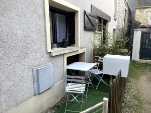 a patio with two chairs and a table and a window at Augustin's house in Héricy