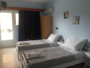 a bedroom with two beds and a door with a window at Tzakis Studios Lassi in Argostoli +4 photos