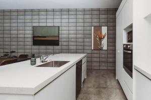 Una cocina blanca con fregadero y encimera. en Perfect On Powderham Prime Inner City Location, en New Plymouth