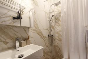 a bathroom with a shower and a white sink at Darius Lux Apartments in Paralia Katerinis