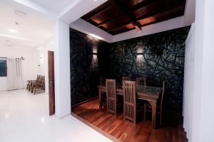 een eetkamer met een tafel en stoelen tegen een muur bij Ransara Resort in Dikwella