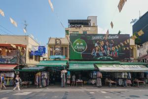a group of shops in a street with people walking by at Dancenter Khaosan Park Hotel in Bangkok