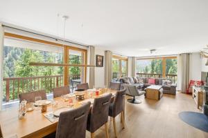 a dining room with a table and chairs and a living room at Chalet Les Rahâs by Mrs Miggins in Grimentz