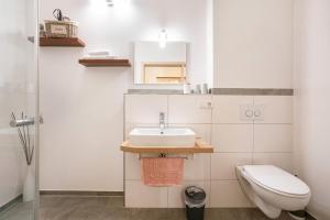 a bathroom with a sink and a toilet at Komfort Apartment Römersberger - 6 in Vogtareuth +31 photos