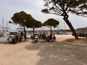 un groupe de personnes assises sur des chaises près d'un port de plaisance dans l'établissement Location, à Antibes 2 autres photos