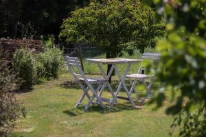 a picnic table and two chairs in the grass at The Homestead - a rural family retreat in Sentry Hill