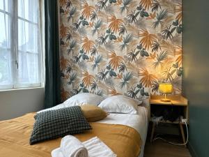a bedroom with a bed with a floral wallpaper at La Maison D'Oscar in Parthenay