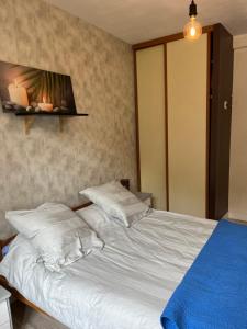 una camera da letto con un letto con lenzuola e cuscini bianchi di SAVIGNAC a Savignac-les-Ormeaux