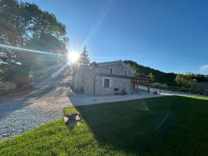 a house with the sun shining on the grass at Oltretempo Agriturismo in Sarsina