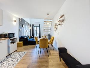 une cuisine et un salon avec une table et des chaises dans l'établissement Le Datrio - Appartement proche des halles - Wifi et climatisation, à Narbonne