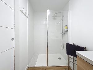 une salle de bain blanche avec une douche avec une porte vitrée dans l'établissement Le Datrio - Appartement proche des halles - Wifi et climatisation, à Narbonne
