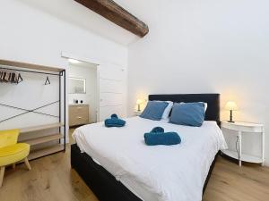 une chambre avec un grand lit avec deux serviettes dessus dans l'établissement Le Datrio - Appartement proche des halles - Wifi et climatisation, à Narbonne