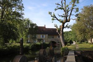 stary dom z drzewem przed nim w obiekcie Le Moulin de Villiers w mieście Gudmont