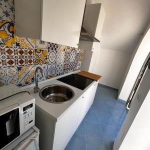 a small kitchen with a sink and a microwave at Maison Emi in Montecorice +12 photos