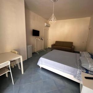 a bedroom with a bed and a table and a couch at Maison Emi in Montecorice