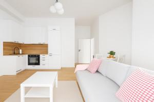 a white living room with a couch and a table at Luxury Design Apartments - Poznańska Warsaw City Center in Warsaw
