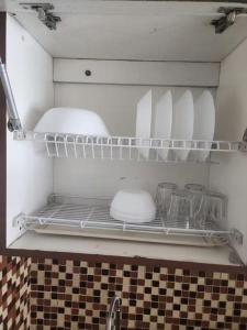 a refrigerator with plates and dishes on a shelf at Jardin B20, Pool View, Netflix & WIFI in Bandung