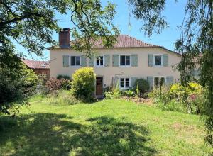 a large white house with a grassy yard at Gite Des Cimes in Baigts-de-Béarn