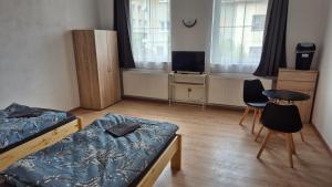 a bedroom with two beds and a table and chairs at Penzion Na Slunci in Jihlava