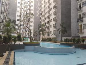 a swimming pool in front of two tall buildings at Jardin B20, Pool View, Netflix & WIFI in Bandung