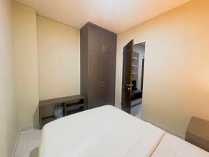 a bedroom with a white bed and a cabinet at Sighma Palem Merah Senopati in Jakarta