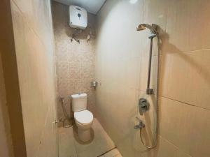 a bathroom with a toilet and a shower at Sighma Palem Merah Senopati in Jakarta