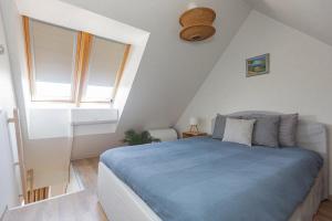 a bedroom with a blue bed and a window at Ievara apartamentai in Palanga +18 photos