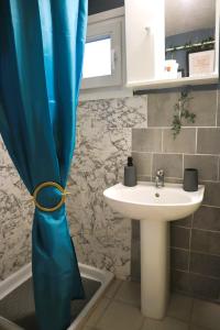 阿斯特里斯La Rosalie的浴室设有水槽和蓝色的浴帘