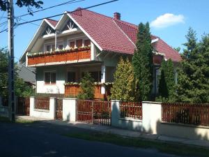 a house with a red roof and a fence at Apartments in Balatonföldvar 45318 in Balatonföldvár